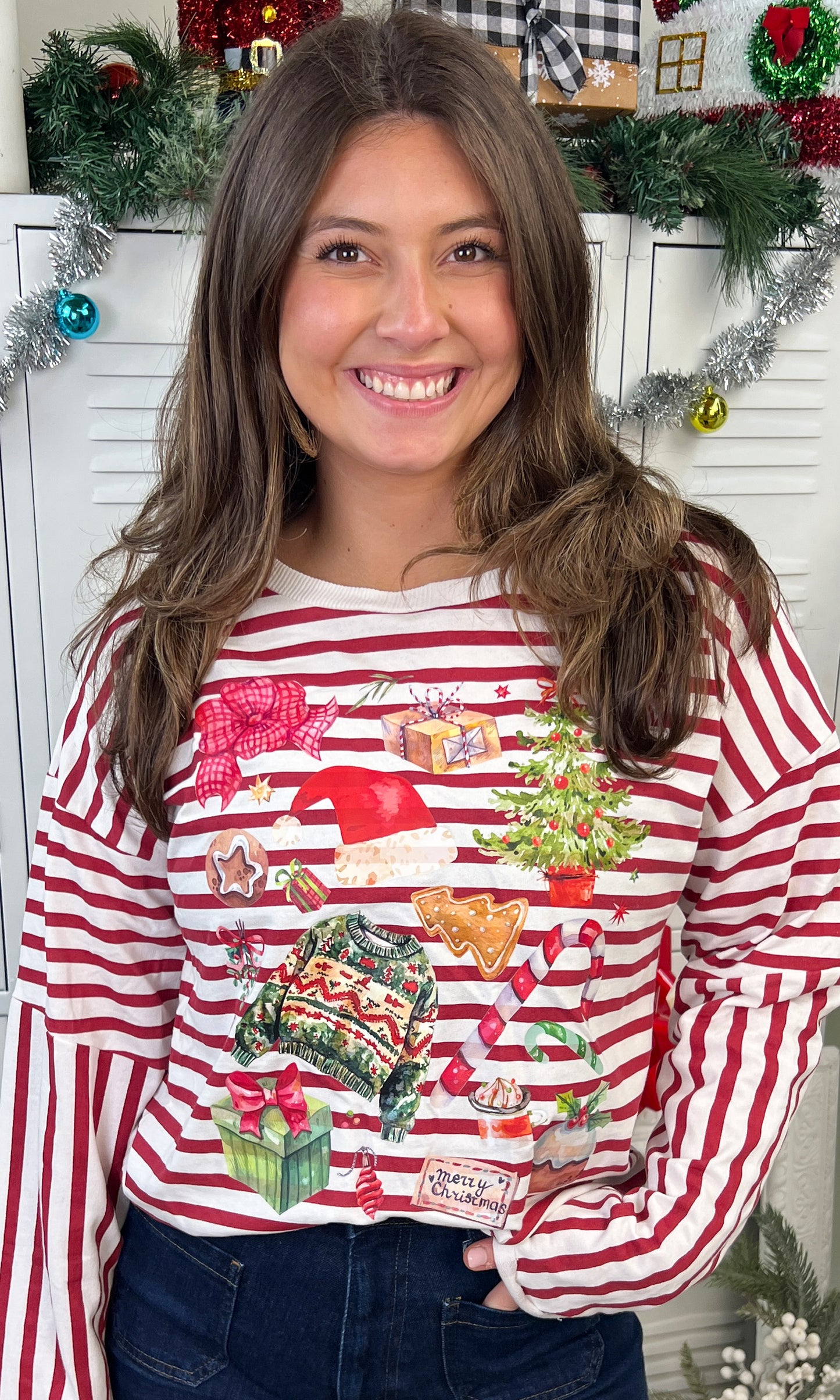 Model wearing a Christmas Collage LS Edgy Striped Graphic Shirt featuring festive prints and vibrant colors.