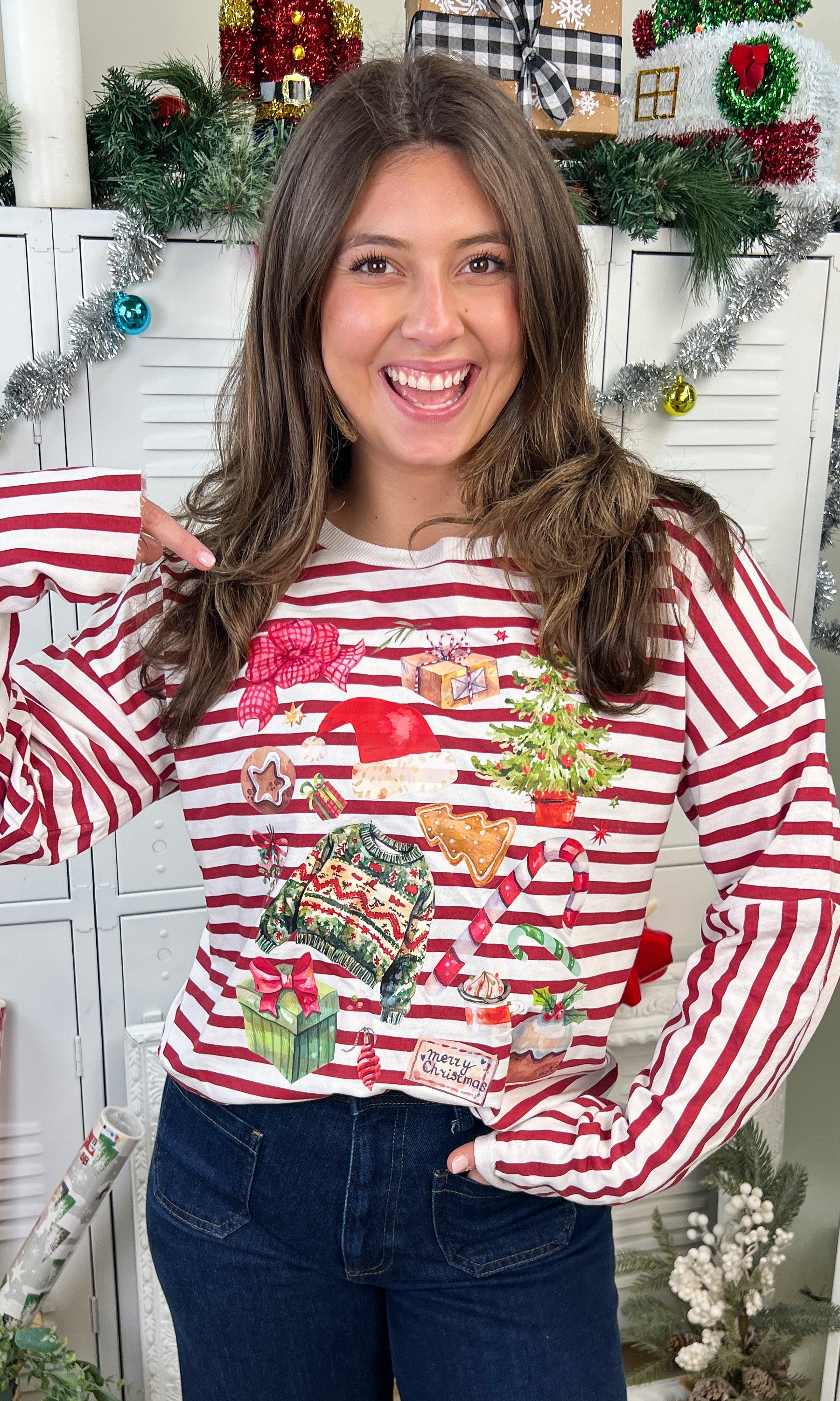 Model wears a Christmas Collage LS Edgy Striped Graphic Shirt featuring festive designs, perfect for holiday celebrations.
