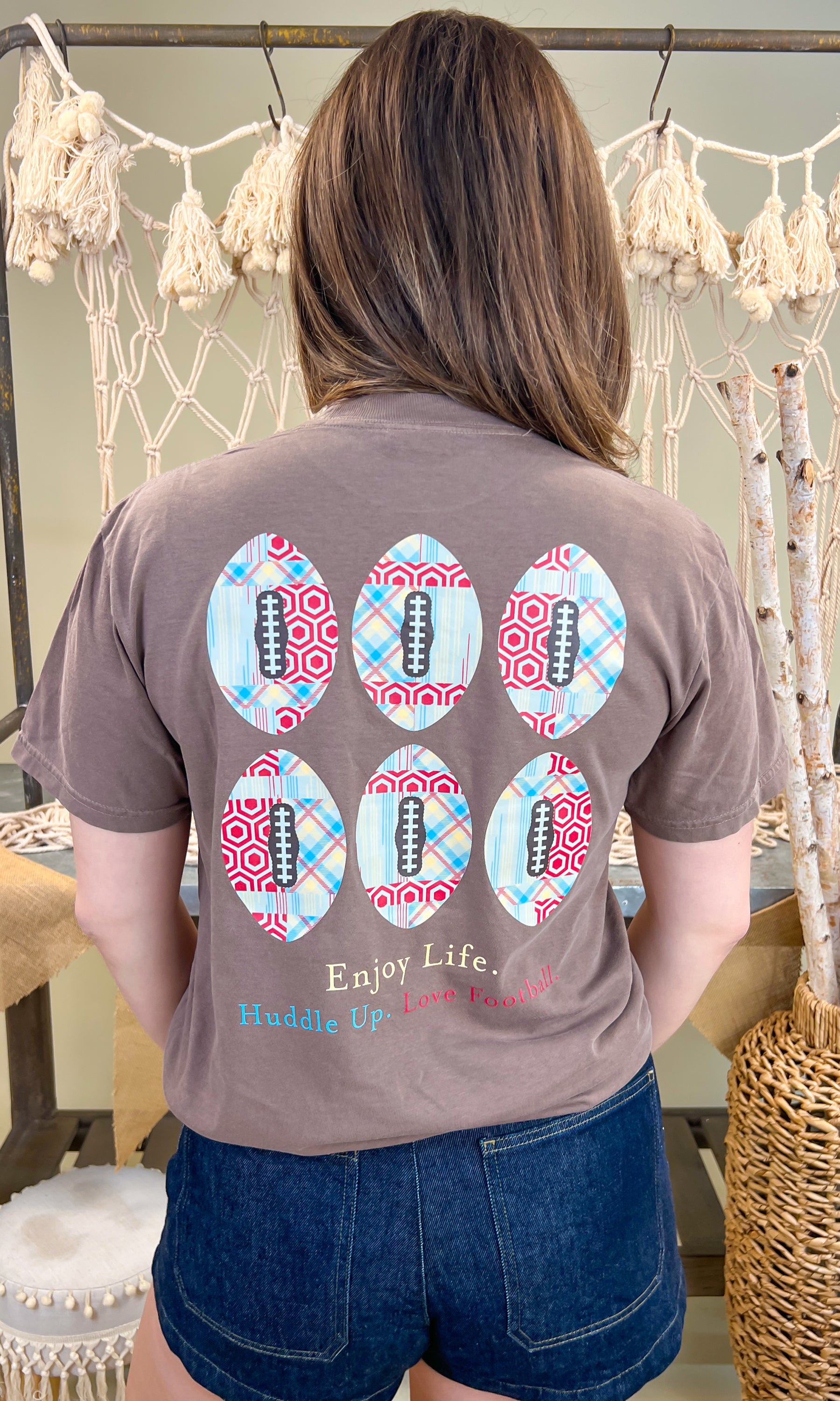 Huddle Up Love Football Comfort Color Graphic T-Shirt offers cozy style for football fans with a fun design on the back.