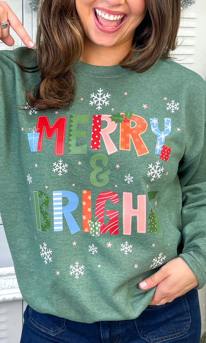 Merry and Bright Snowflakes Christmas Graphic Sweatshirt featuring colorful holiday designs on a cozy green fabric.