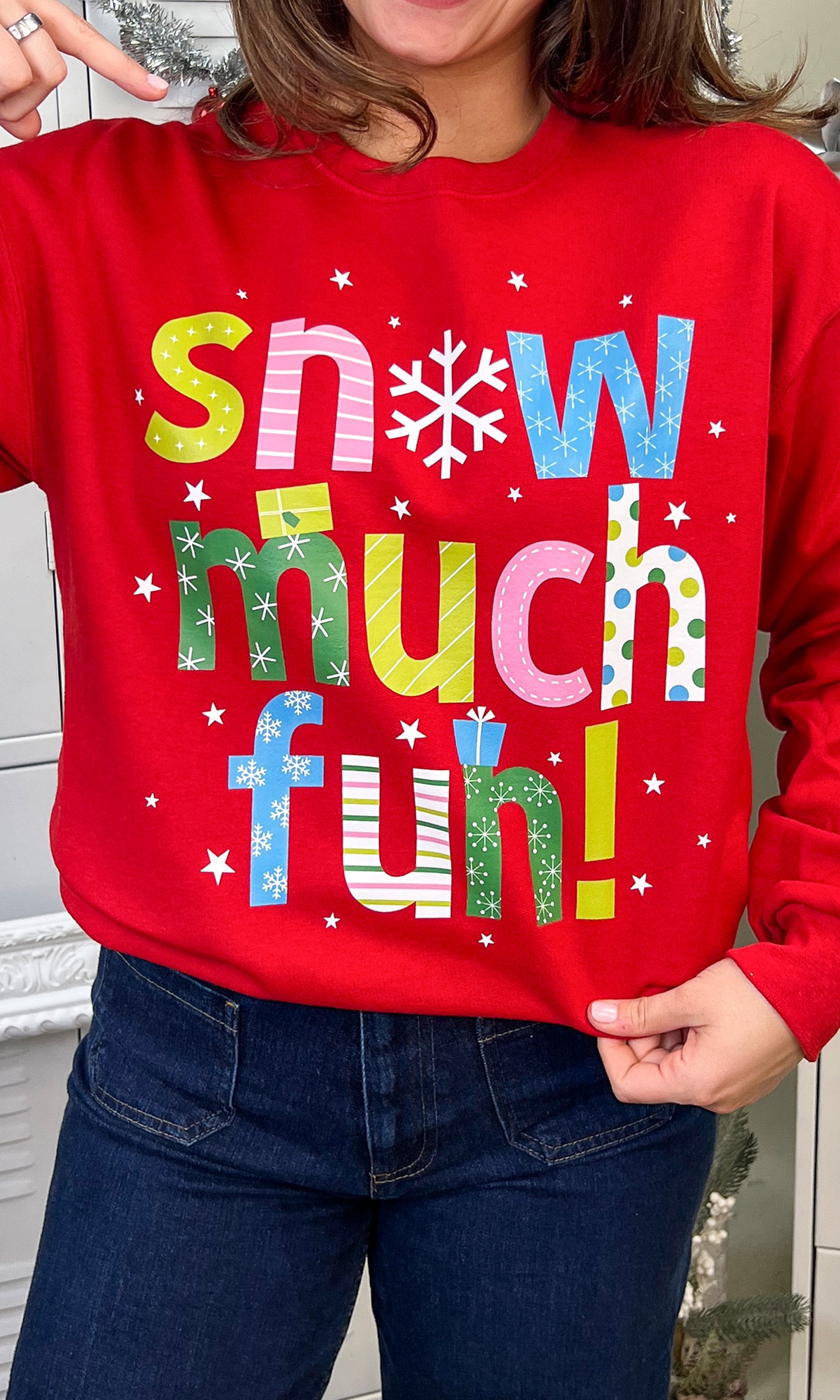 Bright red Snow Much Fun Christmas Graphic Sweatshirt featuring playful lettering, perfect for festive celebrations.