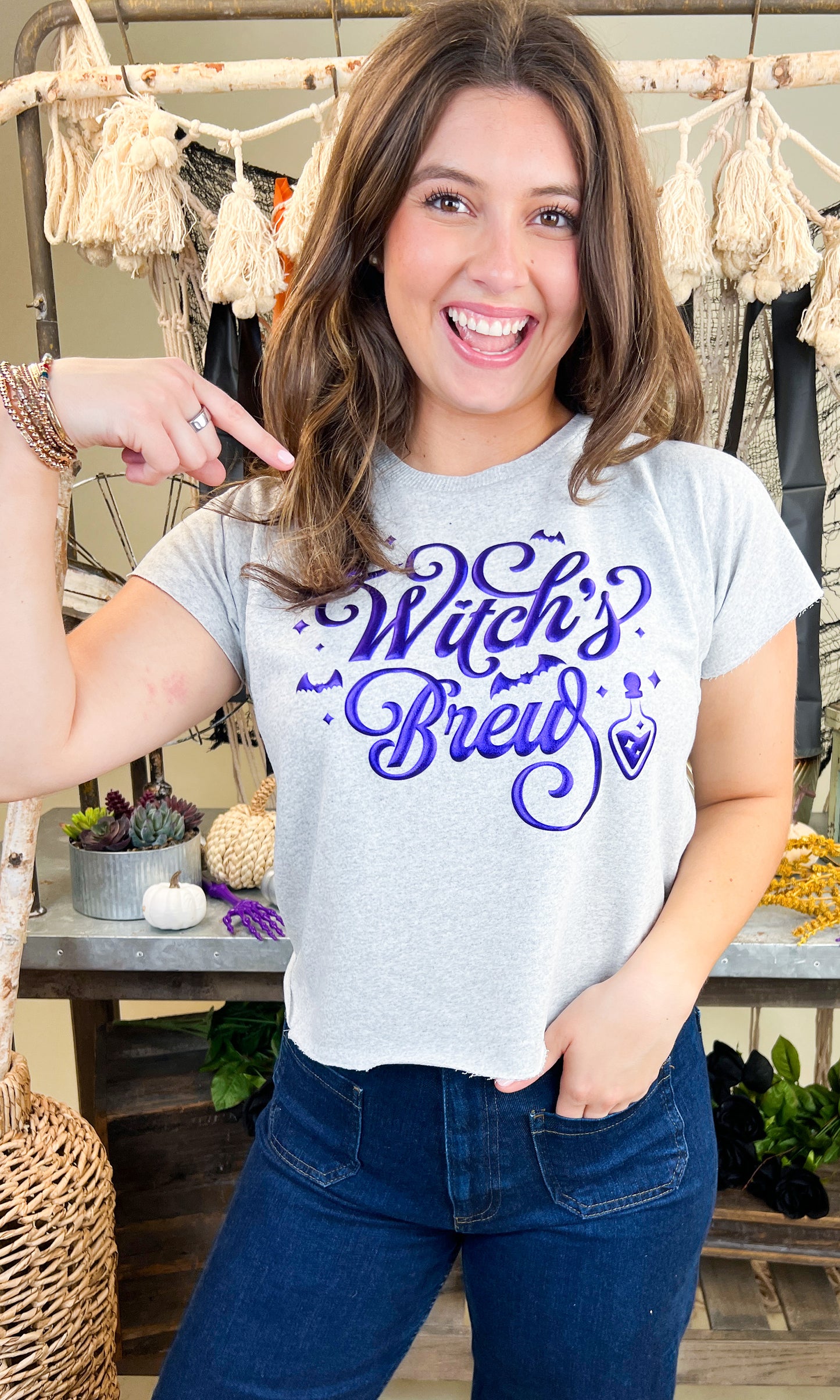 Stylish model showcasing the Witch's Brew Halloween Edgy Graphic Shirt, perfect for festive celebrations.