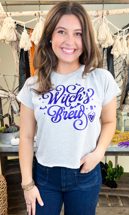 Cute model wearing the Witch's Brew Halloween Edgy Graphic Shirt, showcasing its fun Halloween design. Perfect for festive vibes!
